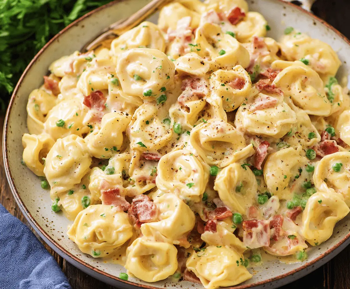 Creamy tortellini carbonara served with crispy pancetta and fresh herbs in a bowl, highlighting a delicious Italian pasta dish