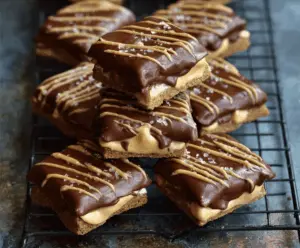 Delicious no-bake buckeye graham crackers topped with creamy peanut butter and chocolate coating, perfect for a sweet snack or dessert