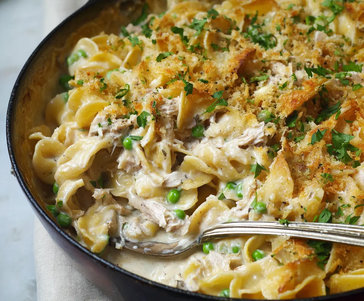 Creamy Tuna Noodle Casserole topped with melted cheese in a baking dish.