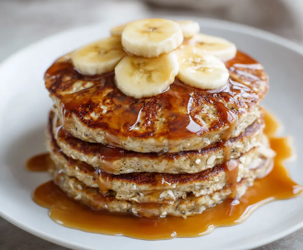 Delicious 3 ingredient banana oatmeal pancakes on a plate, showcasing a healthy breakfast option.
